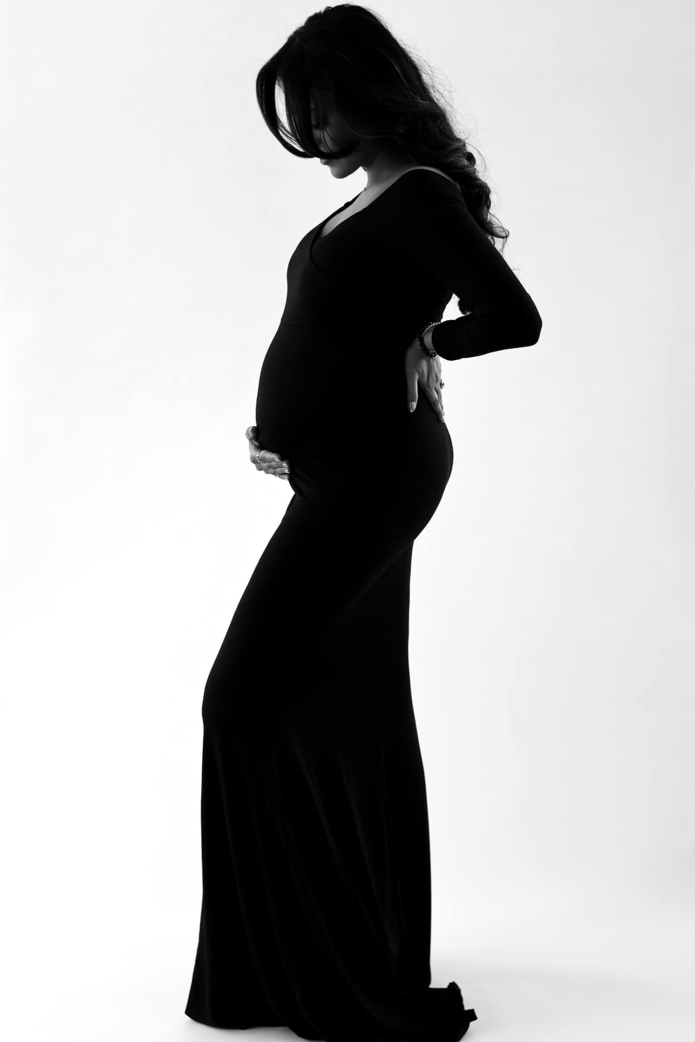 Fine art black and white maternity silhouette, expectant mother in a black gown